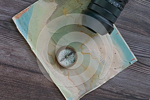 old fashioned compass on a vintage map with camera