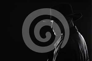 Old fashioned detective in hat on background, black and white effect. Space for text photo