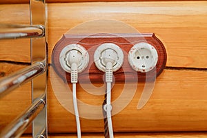 Old fashioned electricity switches, socket, electric wire in on a wooden wall.