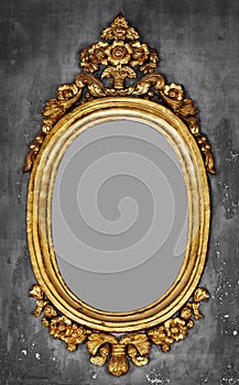 Old-fashioned gilt frame for a mirror on a concrete wall photo