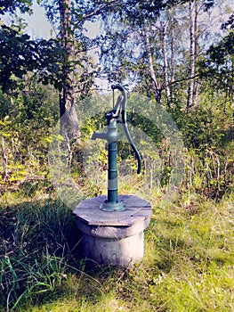 An old fashioned hand powered water pump in garden