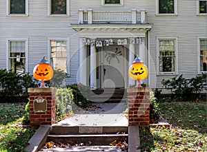 Old fashioned house with lit jack-lanterns and a spider on the door photo