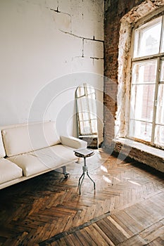 Old fashioned interior big wooden window and mirror, white sofa in old vintage living room with brick walls