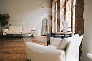 Old fashioned interior big wooden window and mirror, white sofa in old vintage living room with brick walls