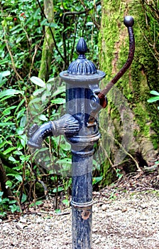 Old fashioned iron water pump used for pumping water out of an u