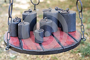 Old-fashioned iron weights on a wooden tray of an old scale