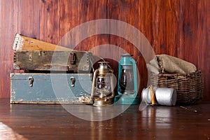 Old-fashioned kerosene lantern lamps with oil lamps in an antique warehouse warehouse with vintage wooden drawers. wicker basket,