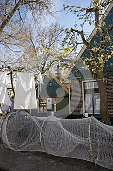 Old-fashioned laundry drying in wind on clotheslines. Walking in historical Dutch fisherman`s village in North-Holland, Enkhuizen