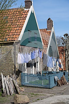 Old-fashioned laundry drying in wind on clotheslines. Walking in historical Dutch fisherman`s village in North-Holland, Enkhuizen