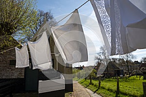 Old-fashioned laundry drying in wind on clotheslines. Walking in historical Dutch fisherman`s village in North-Holland, Enkhuizen