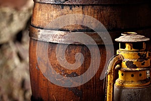 Old fashioned light kerosene lantern style oil lamp and barrels.closeup