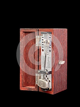 An old fashioned metronome ,made from wood box, black background, Selective focus