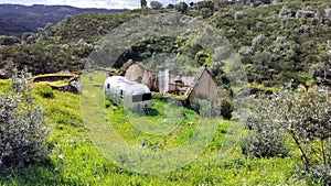 Old-fashioned residential trailer parked on the green besides the ruined rural house, near Belver, Portugal