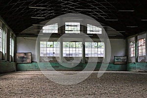 Old fashioned riding hall with sandy covering without people