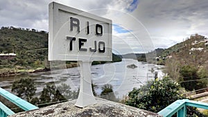 Old-fashioned road sign reading \'RIO TEJO\' in Portuguese, on Belver Bridge across Tagus River