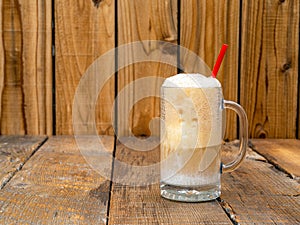 Old Fashioned Root Beer ice cream float on a rustic wooden background with copy space.