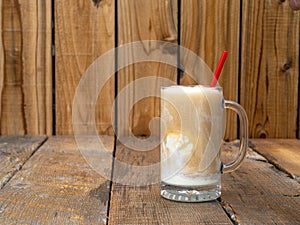 Old Fashioned Root Beer ice cream float on a rustic wooden background with copy space.