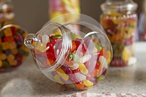 An old fashioned round glass jar of delicious jelly beans, with another out of focus jar in the background