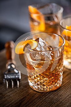 Old fashioned rum cocktail on ice with orange zest garnish