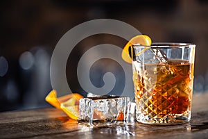 Old fashioned rum drink on ice with orange zest garnish