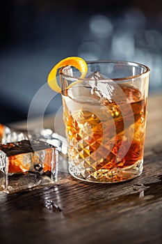 Old fashioned rum drink on ice with orange zest garnish