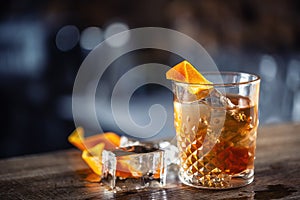 Old fashioned rum drink on ice with orange zest garnish