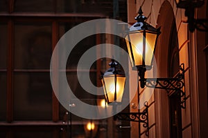 Old fashioned street lamp at night. Brightly lit street lamps at sunset. Decorative lamps. Magic lamp with a warm yellow light in