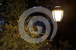 Old-fashioned street lamp in a public park at night on Manhattan`s Upper East Side, New York City