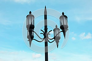 Old fashioned street light lamp against cloudy sky