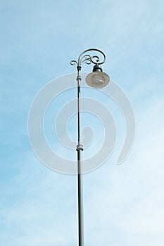 Old fashioned street light lamp against cloudy sky