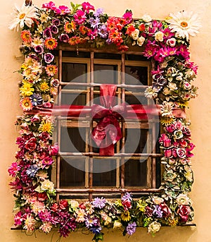 An old fashioned style window with flowers in small Portugese town Obidos.