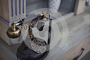 Old Fashioned telephone sitting on a desk. Vintage piece of technology