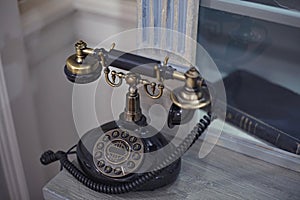 Old Fashioned telephone sitting on a desk. Vintage piece of technology