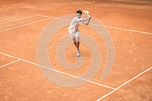 old-fashioned tennis player training with wooden racket