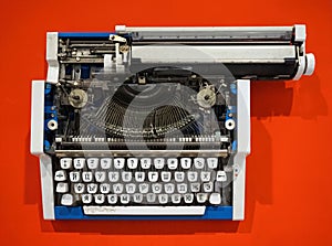 Old-fashioned typewriter on a bright orange background