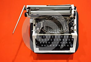 Old-fashioned typewriter on a bright orange background