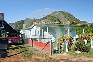 Old fashioned vintage car by summer colorful house in the town of Vinales, Cuba