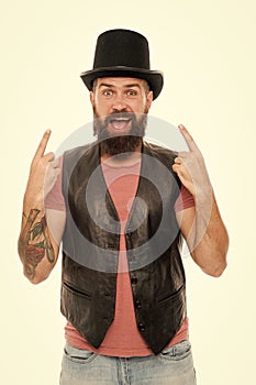 Old fashioned and vintage. Caucasian guy pointing at vintage top hat accessory or headgear. Bearded man wearing cylinder