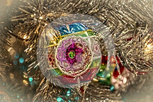 Old fashioned vintage glass Christmas ornament hanging on silver tree - Closeup and bokeh