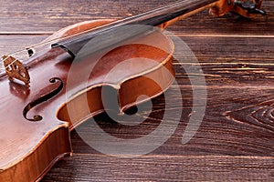 Old-fashioned violin on wooden background.
