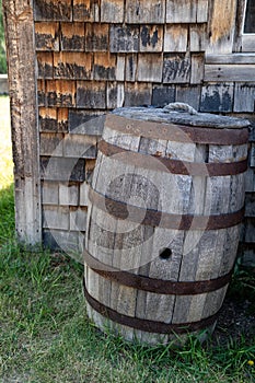 Old fashioned whiskey barrel sitting outside of an abandoned building. Taken in Bannack Ghost Town Montana