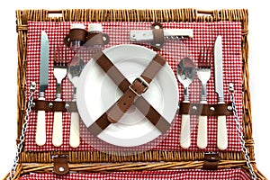 Old fashioned wicker picnic basket with cutlery