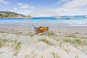 Old-fashioned wooden clinker dinghy pulled on beach photo