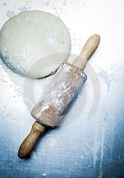 Old-fashioned wooden rolling pin and dough