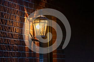 Old fashoned glass wall mounted lantern on a brick wall photo