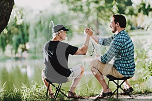 Old Father with Bearded Son Fishing on River.