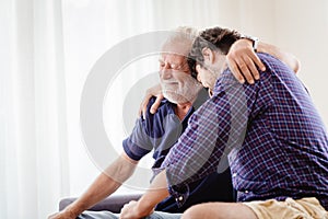 Old father elder grateful happy smile and embrace his son at home