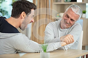 old father and son playing arm wrestle photo