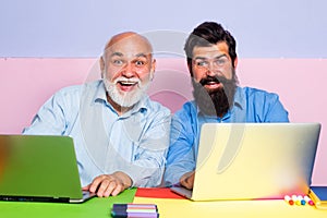 Old father and son using notebook. Male workers chatting at office desk meeting. Male Multi Generation Family using