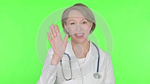 Old Female Doctor Talking on Online Video Call on Green Background